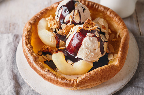 Piled high with juicy pears, vanilla ice cream and creamy chocolate sauce, this surprising pud will definitely become a firm family favourite.