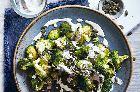 Forget plain boiled veg and take your side dishes up a notch with this simple roasted broccoli and spiced yogurt. The broccoli becomes irresistibly crisp and caramelised in the oven, before being finished with creamy curried yogurt and pumpkin seeds.