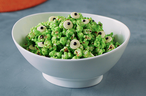 Spooky, slimy and super-snackable, this oozy green popcorn recipe, complete with googly eyes is perfect for a spooky movie night. Coated in a sweet white chocolate slime, this homemade Halloween popcorn is easy to make and fun to eat, too. 
