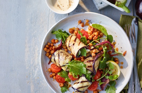 This stylish vegetarian dinner combines smoky, griddled aubergine slices, rolled up and stuffed with halloumi and basil and baked until soft, with spicy harrisa chickpeas and a creamy tahini dressing that brings all the flavours together beautifully
