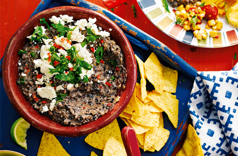 Load up your tortilla chips with this rich, Mexican black bean paste or 'frijoles', which are packed with chilli and garlic and topped with tangy feta and sour cream