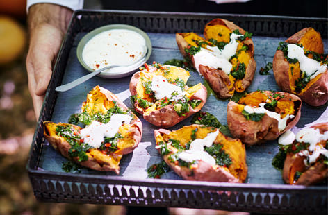 Roasted sweet potatoes are topped with a generous helping of a spicy gremolata and a dollop of soured cream in this delicious Halloween party platter.