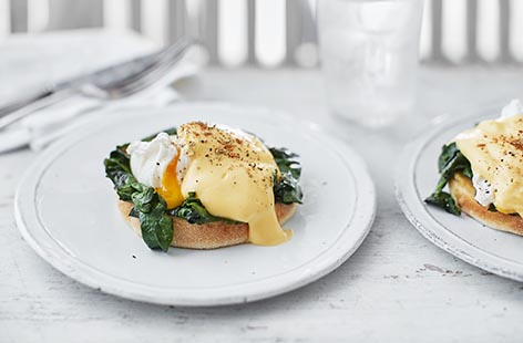 Perfectly poached eggs, silky spinach and creamy hollandaise sit atop toasted muffins in this indulgent brunch recipe