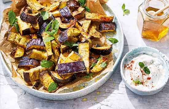 Baked aubergine ‘chips’ make a moreish easy starter or side dish. Chunky wedges of aubergine are coated in polenta for maximum crunch and baked until crisp, plus a sweet drizzle of honey helps them caramelise in the oven. 