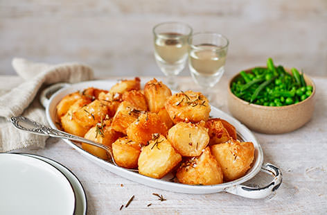 Master how to make roast potatoes that are wonderfully golden and crisp on the outside with heavenly fluffy centres. Seasoned with a fragrant blend of rosemary and garlic, your classic roasted potatoes don't get much better than this.