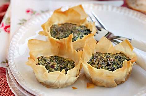 Excellent as pre-dinner canapés, these light and tasty spinach and filo tarts are a cinch to make. Blanched spinach, eggs, Parmesan, mustard and crème fraîche make up the savoury filling, with each tart baked in the oven till crisp and golden.
