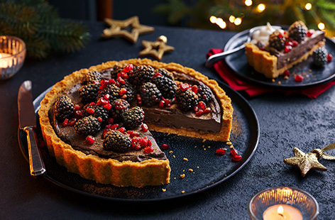 Give a classic chocolate tart a festive twist with this spiced flourless chocolate fruit torte recipe. This totally vegan Christmas dessert recipe has a smooth chocolate ganache studded with juicy dried fruit on a spiced gingernut base for an indulgent way to end your Christmas dinner.