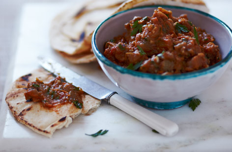 Zaalouk is a traditional Moroccan salad made with aubergines and tomatoes, seasoned with garlic, cumin and chilli. Here we’ve mashed it into a dip, topped with fresh herbs and served with flatbreads.